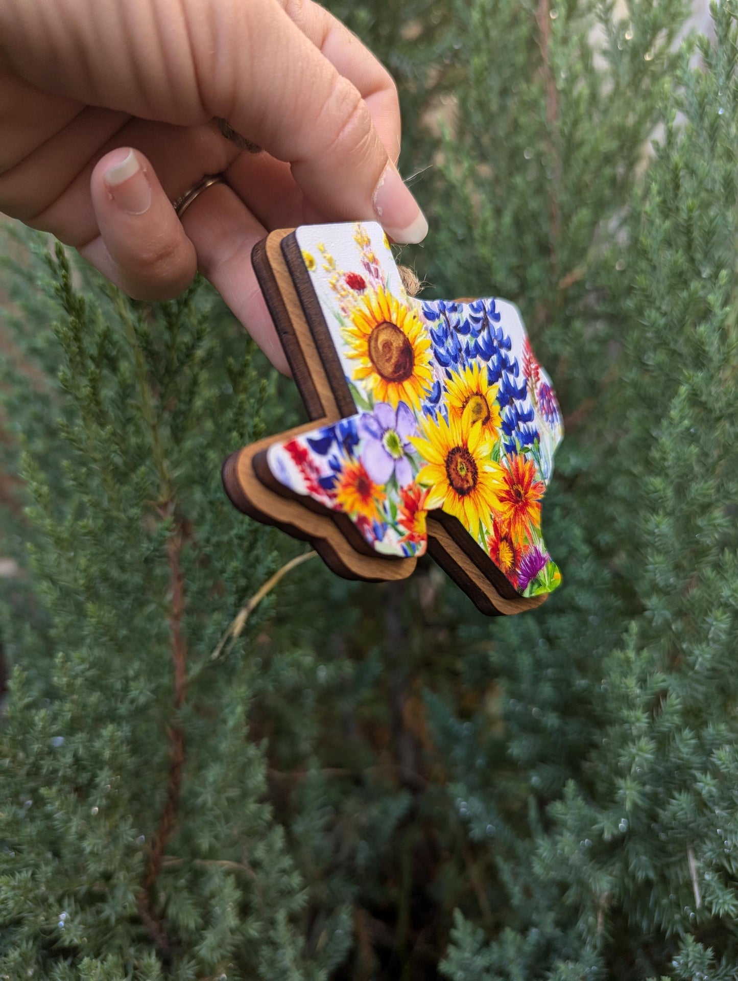 Texas Wildflower Christmas Ornament; bluebonnets, Indian paintbrushes, fire wheels, sunflowers, and coneflowers inside the state of Texas