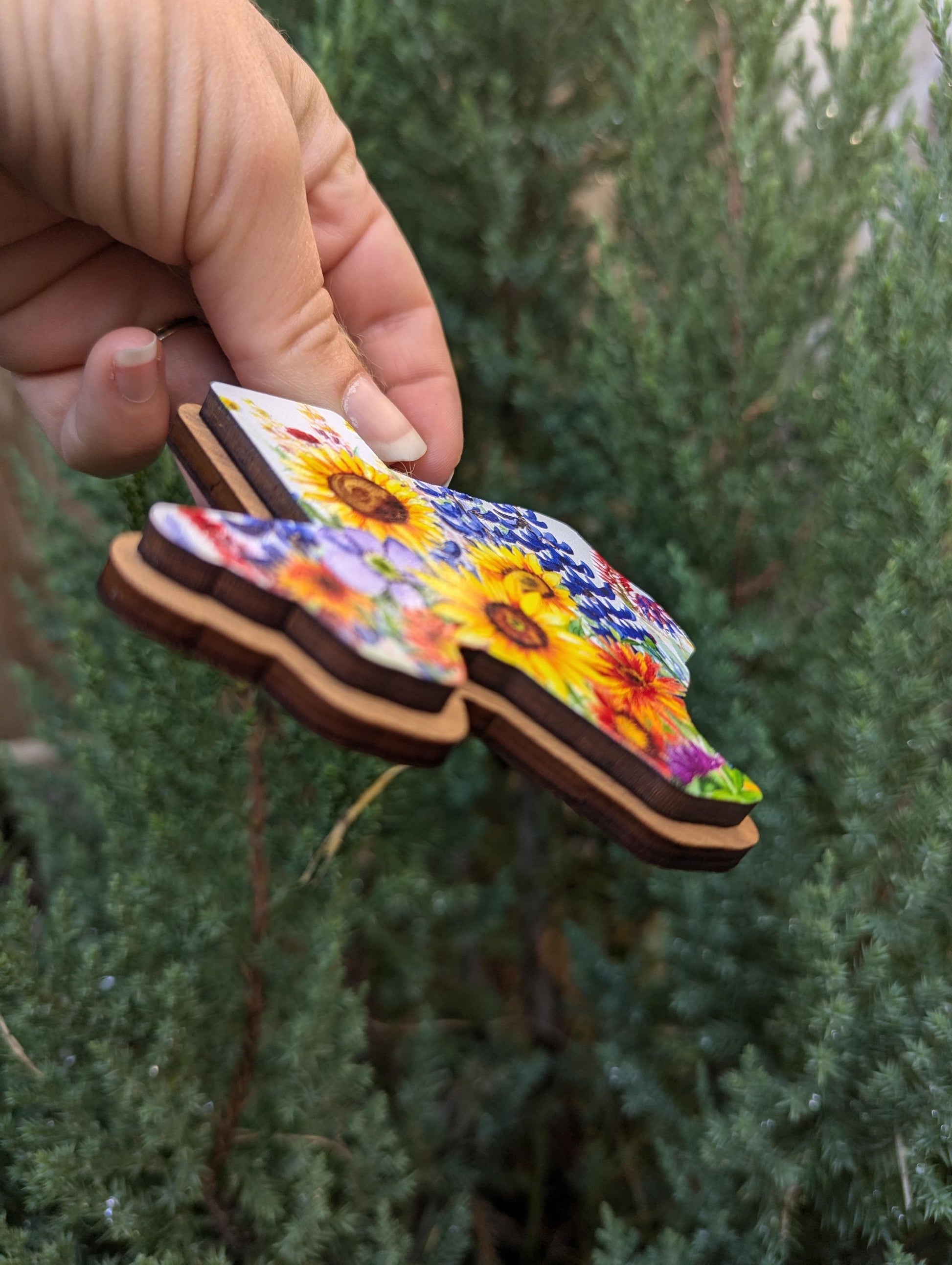 Texas Wildflower Christmas Ornament; bluebonnets, Indian paintbrushes, fire wheels, sunflowers, and coneflowers inside the state of Texas